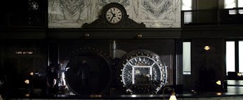 Movie still from “Public Enemies” (2009), directed by Michael Mann – A clock is shown on the side of a wall; Wide shot, Low angle