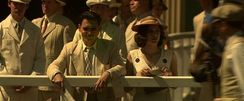 Movie still from “Public Enemies” (2009), directed by Michael Mann – A man and a woman are standing next to each other; Medium shot, Low angle