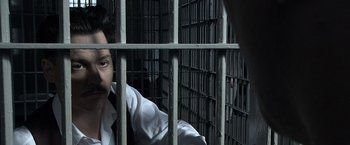 Movie still from “Public Enemies” (2009), directed by Michael Mann – A man behind bars in a jail cell; Close Up shot, High angle