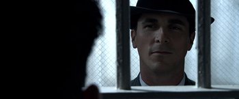 Movie still from “Public Enemies” (2009), directed by Michael Mann – A man wearing a black hat looking at himself in a mirror; Close Up shot, Over the shoulder angle