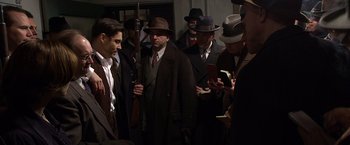 Movie still from “Public Enemies” (2009), directed by Michael Mann – A group of men standing next to each other wearing hats; Medium shot, High angle