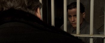 Movie still from “Public Enemies” (2009), directed by Michael Mann – A man looking at himself in the mirror in a jail cell; Close Up shot, Over the shoulder angle