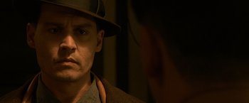 Movie still from “Public Enemies” (2009), directed by Michael Mann – A person wearing a hat; Close Up shot, Over the shoulder angle