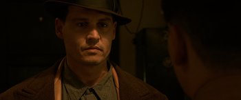 Movie still from “Public Enemies” (2009), directed by Michael Mann – A person wearing a hat; Close Up shot, Over the shoulder angle