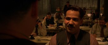 Movie still from “Public Enemies” (2009), directed by Michael Mann – A group of men sitting at tables in a room; Close Up shot, Over the shoulder angle