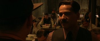 Movie still from “Public Enemies” (2009), directed by Michael Mann – A group of men sitting in a room with microscopes; Close Up shot, Over the shoulder angle