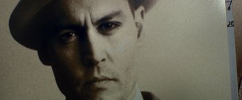 Movie still from “Public Enemies” (2009), directed by Michael Mann – A man's face in black - and - white photo; Extreme Close Up shot, Low angle