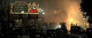 Movie still from “Public Enemies” (2009), directed by Michael Mann – A group of people standing on a street at night; Extreme Wide shot, High angle