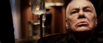 Movie still from “Punisher: War Zone” (2008), directed by Lexi Alexander – An older man sitting in a chair in front of a lamp; Close Up shot, Low angle