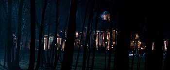 Movie still from “Punisher: War Zone” (2008), directed by Lexi Alexander – A house in the woods at night with lights on; Extreme Wide shot, Low angle