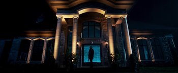 Movie still from “Punisher: War Zone” (2008), directed by Lexi Alexander – A person standing in front of a building at night; Wide shot, Low angle