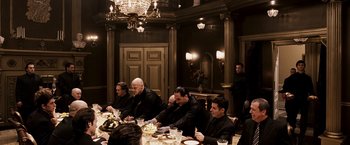 Movie still from “Punisher: War Zone” (2008), directed by Lexi Alexander – A group of men sitting at a dinner table; Wide shot, High angle