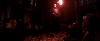 Movie still from “Punisher: War Zone” (2008), directed by Lexi Alexander – A group of people sitting around a table with glasses; Wide shot, Low angle