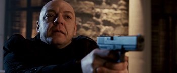 Movie still from “Punisher: War Zone” (2008), directed by Lexi Alexander – A man holding a gun in his right hand; Close Up shot, Low angle