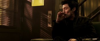 Movie still from “Punisher: War Zone” (2008), directed by Lexi Alexander – A man sitting on a couch eating something; Close Up shot, Low angle
