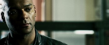 Movie still from “Punisher: War Zone” (2008), directed by Lexi Alexander – A person wearing a black jacket; Close Up shot, Over the shoulder angle