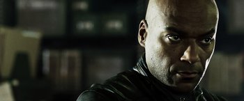 Movie still from “Punisher: War Zone” (2008), directed by Lexi Alexander – A man with a bald head wearing a leather jacket; Close Up shot, Low angle
