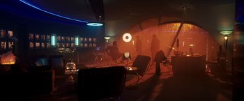 Movie still from “Punisher: War Zone” (2008), directed by Lexi Alexander – People are sitting in chairs in a dark room; Wide shot, High angle