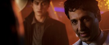 Movie still from “Punisher: War Zone” (2008), directed by Lexi Alexander – A man standing next to another man in front of a building; Close Up shot, Over the shoulder angle