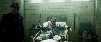 Movie still from “Punisher: War Zone” (2008), directed by Lexi Alexander – A man sitting in a hospital bed with his feet crossed; Wide shot, High angle