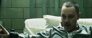 Movie still from “Punisher: War Zone” (2008), directed by Lexi Alexander – A man sitting on a couch in a room; Close Up shot, High angle