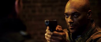 Movie still from “Punisher: War Zone” (2008), directed by Lexi Alexander – A man holding a gun in his hands; Close Up shot, Low angle