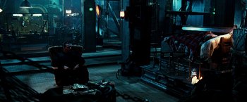 Movie still from “Punisher: War Zone” (2008), directed by Lexi Alexander – A person sitting on a chair in a room; Wide shot, High angle