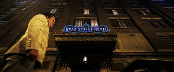 Movie still from “Punisher: War Zone” (2008), directed by Lexi Alexander – A building that has a sign on top of it that says " brad street hotel "; Extreme Wide shot, Low angle