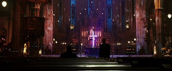 Movie still from “Punisher: War Zone” (2008), directed by Lexi Alexander – Two people sitting in front of a cross in a church; Extreme Wide shot, Low angle