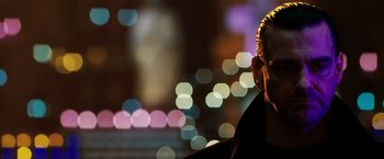 Movie still from “Punisher: War Zone” (2008), directed by Lexi Alexander – A person in a city at night; Close Up shot, Over the shoulder angle