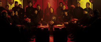 Movie still from “Punisher: War Zone” (2008), directed by Lexi Alexander – A group of people sitting around a table; Medium shot, High angle