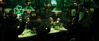 Movie still from “Punisher: War Zone” (2008), directed by Lexi Alexander – A group of men sitting at a long table drinking beer; Wide shot, High angle
