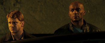 Movie still from “Punisher: War Zone” (2008), directed by Lexi Alexander – A man in a black shirt is looking at the camera; Close Up shot, Low angle