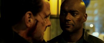 Movie still from “Punisher: War Zone” (2008), directed by Lexi Alexander – A man looking at another man in a mirror; Close Up shot, Over the shoulder angle