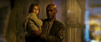 Movie still from “Punisher: War Zone” (2008), directed by Lexi Alexander – A man and a girl are standing next to each other; Medium shot, Low angle