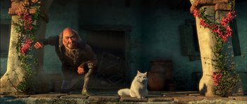 Movie still from “Puss in Boots” (2011), directed by Chris Miller – A white cat sitting next to a person; Wide shot, Low angle