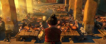 Movie still from “Puss in Boots” (2011), directed by Chris Miller – A group of people sitting at a table with plates of food on it; Wide shot, Over the shoulder angle