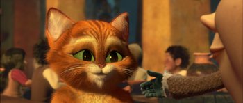 Movie still from “Puss in Boots” (2011), directed by Chris Miller – An orange cat with green eyes is looking at a hand; Close Up shot, Over the shoulder angle