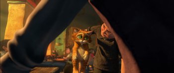 Movie still from “Puss in Boots” (2011), directed by Chris Miller – A person with an orange and white cat in a room; Medium shot, Over the shoulder angle