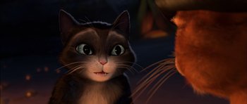 Movie still from “Puss in Boots” (2011), directed by Chris Miller – A cat is looking at the camera in a dark room; Close Up shot, High angle