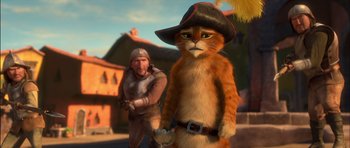 Movie still from “Puss in Boots” (2011), directed by Chris Miller – An orange cat wearing a black hat next to a man; Medium shot, Over the shoulder angle