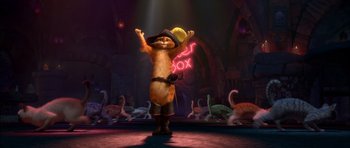 Movie still from “Puss in Boots” (2011), directed by Chris Miller – A cat is standing in front of a flock of flamingos; Wide shot, Low angle