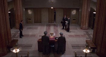 Movie still from “Quiz Show” (1994), directed by Robert Redford – A group of men standing around a lobby; Extreme Wide shot, Overhead angle