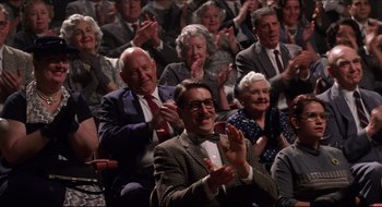Movie still from “Quiz Show” (1994), directed by Robert Redford – An old man and a group of people clapping; Medium shot, Low angle
