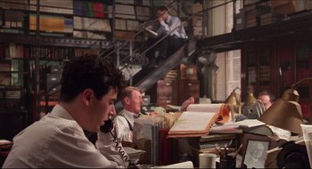 Movie still from “Quiz Show” (1994), directed by Robert Redford – A man sitting at a desk talking on the phone; Wide shot, High angle