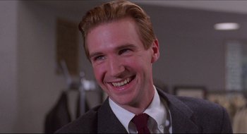 Movie still from “Quiz Show” (1994), directed by Robert Redford – A man in a suit and tie smiling for the camera; Close Up shot, Low angle
