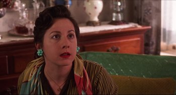 Movie still from “Quiz Show” (1994), directed by Robert Redford – A woman sitting on top of a couch looking up at the sky; Close Up shot, Over the shoulder angle