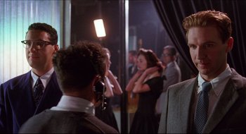 Movie still from “Quiz Show” (1994), directed by Robert Redford – A group of people standing in front of a mirror; Medium shot, Over the shoulder angle