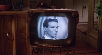 Movie still from “Quiz Show” (1994), directed by Robert Redford – An old tv with a picture of a man on the screen; Close Up shot, Over the shoulder angle