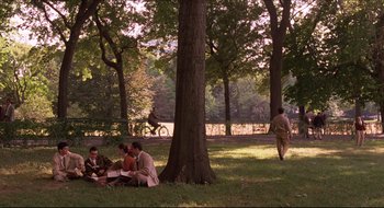 Movie still from “Quiz Show” (1994), directed by Robert Redford – A group of people sitting under a tree in a park; Extreme Wide shot, High angle